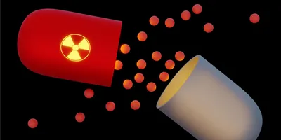 Illustration of a radioactive capsule releasing glowing particles against a black background.