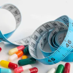 A blue measuring tape with pills on a white background