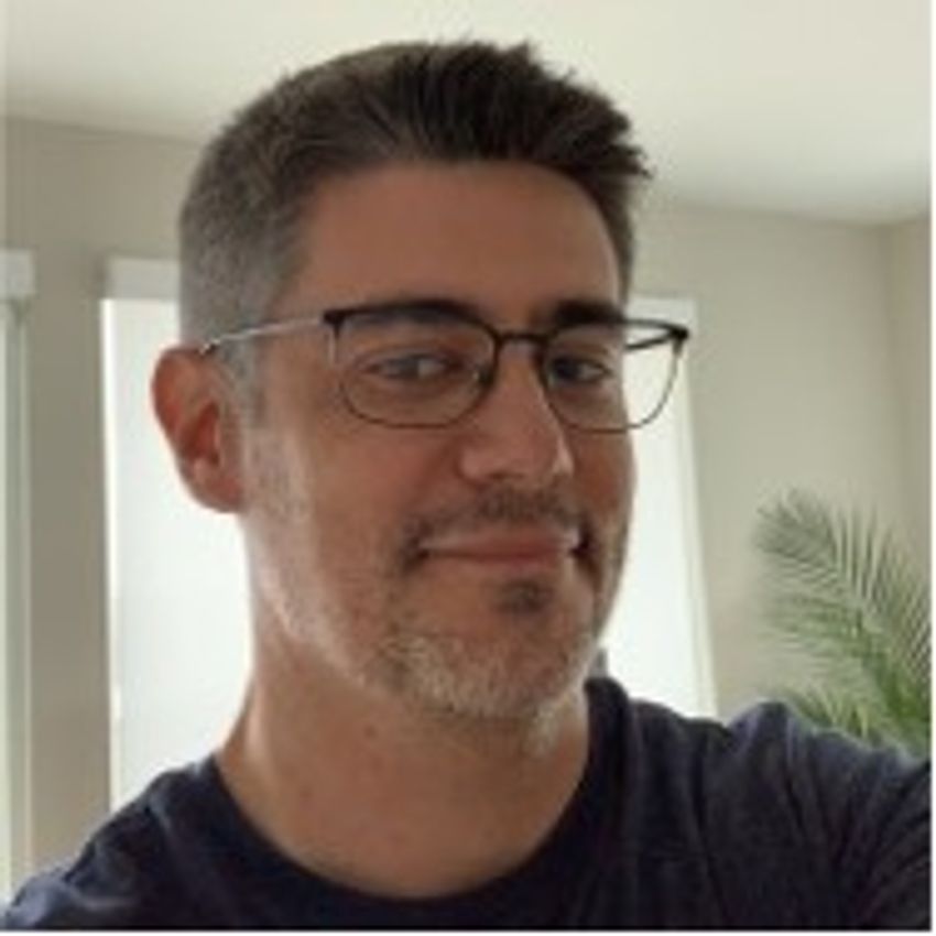 Headshot of Rodrigo Cristofoletti, wearing glasses and a black shirt.