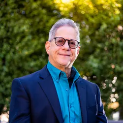 Headshot of Russ Lebovitz, wearing a blue suit and glasses