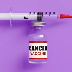 A syringe positioned horizontally above a small vial labeled “cancer vaccine” against a solid purple background.