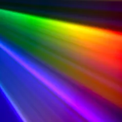 Abstract rainbow-colored beams of light spreading across a dark background.