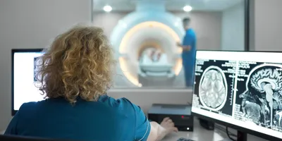 A female technician doing an MRI scan of a patient’s brain.